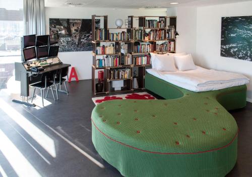 a bedroom with a green bed and a desk and a library at SWEETS - Sluis Haveneiland in Amsterdam