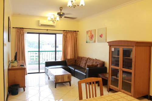 ein Wohnzimmer mit Sofa und Tisch in der Unterkunft Kota Kinabalu Marina Homestay in Kota Kinabalu