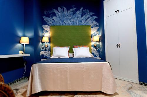 Un pat sau paturi într-o cameră la Ritual Sevilla Suite Alameda 5