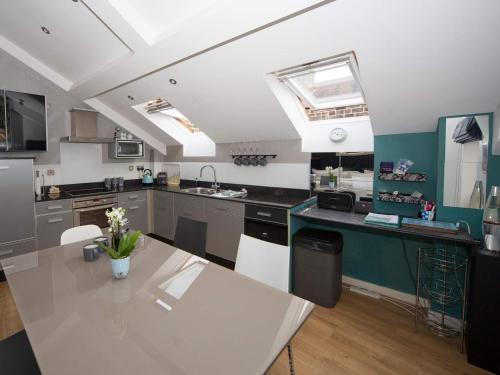 a kitchen with a table and a counter top at Regent Penthouse in Harrogate
