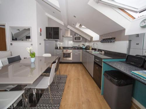 uma cozinha com uma mesa e uma bancada em Regent Penthouse em Harrogate