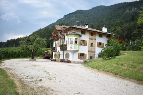 ein Haus auf einer unbefestigten Straße neben einem Berg in der Unterkunft Agriturismo Maso Tafol in Cloz
