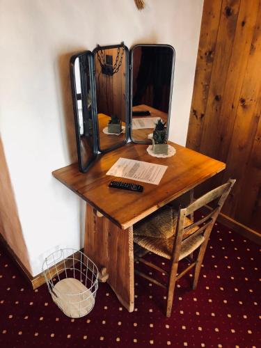 a wooden table with a mirror on a wall at Le Coin Savoyard in Combloux