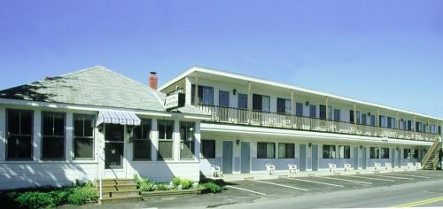 a large white building with a balcony on it at Seagrass Inn in Old Orchard Beach