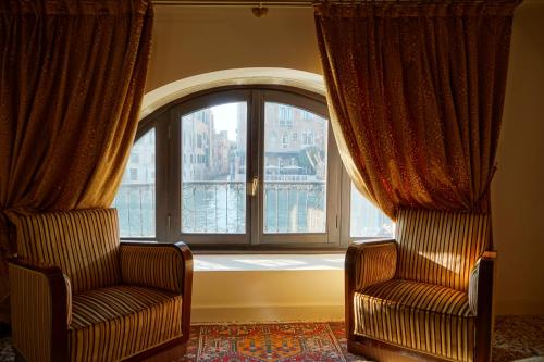 two chairs in a room with a large window at Granda Sweet Suites in Venice