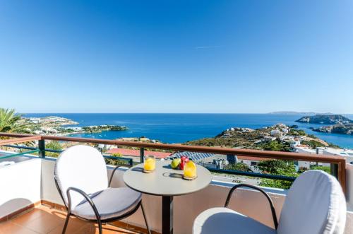 a balcony with a table and chairs and the ocean at Pela Mare Hotel in Agia Pelagia