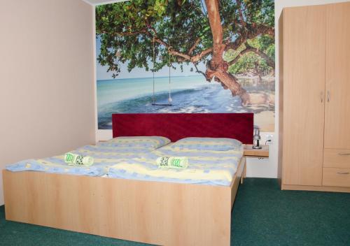 1 dormitorio con 1 cama con una pintura en la pared en Turistická Ubytovňa Osada en Liptovská Osada