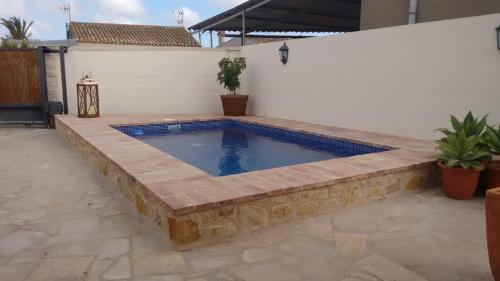 una piscina en un patio trasero con un patio de piedra en Casa Paca, en Deltebre