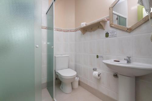 a bathroom with a toilet and a sink at Morada Baden Baden in Bombinhas