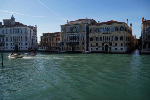 a boat in the water in front of buildings at Granda Sweet Suites in Venice