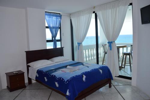 a bedroom with a bed with a view of the ocean at Casa Blanca Hotel Boutique in Santa Marianita