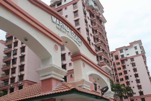 ein Gebäude vor einem hohen Gebäude in der Unterkunft Kota Kinabalu Marina Homestay in Kota Kinabalu