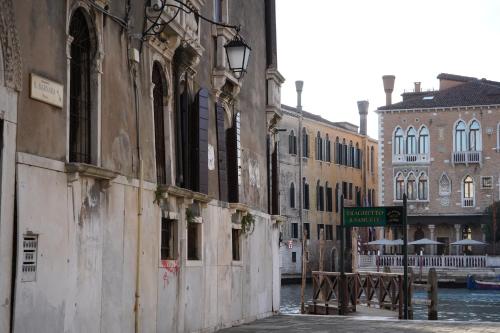 a street with buildings and a sign on a canal at Granda Sweet Suites in Venice