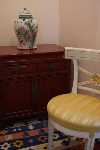 a vase sitting on top of a dresser next to a chair at Granda Sweet Suites in Venice