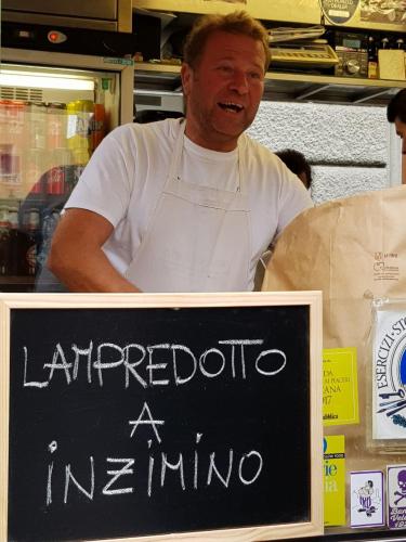 a man is standing in a store with a sign at Appartamento Signoria in Florence