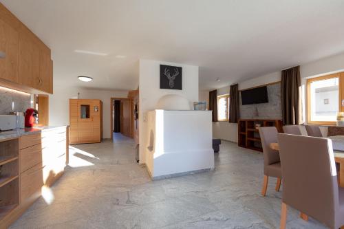 a kitchen with a white refrigerator in a room at Alpen Apart Heiss - DELUXE XL Apartments in Prutz