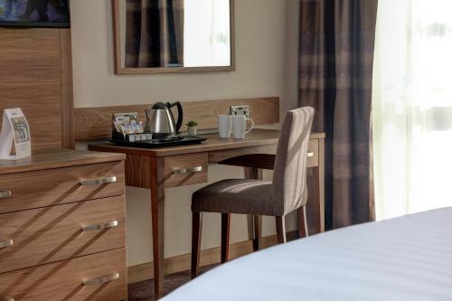 a room with a desk and a chair in a room at Best Western Kings Manor in Edinburgh