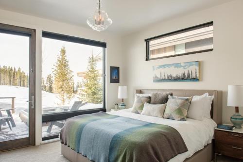 a bedroom with a bed and a sliding glass door at Tanager House in Big Sky