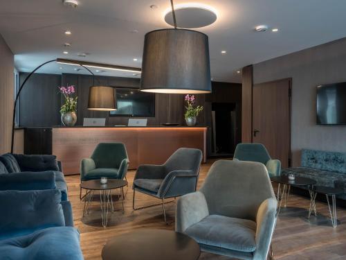 a waiting room with blue chairs and tables at Innspire Hotel in Munich