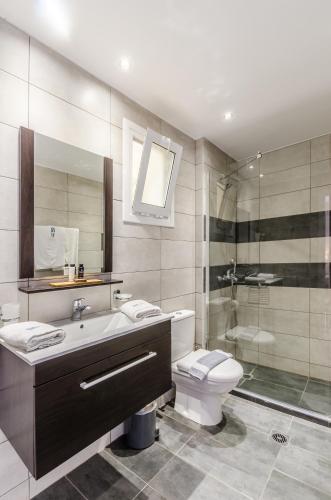 a bathroom with a sink and a toilet and a shower at Pela Mare Hotel in Agia Pelagia