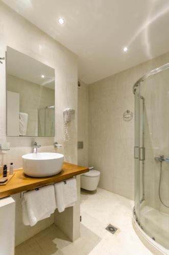 a bathroom with a sink and a shower at Pela Mare Hotel in Agia Pelagia