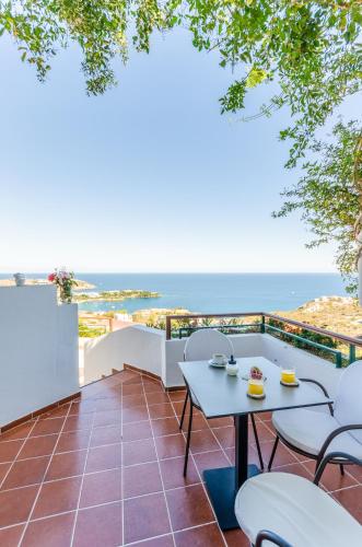 a balcony with a table and chairs and the ocean at Pela Mare Hotel in Agia Pelagia