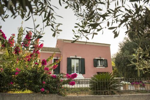 a pink house with flowers in front of it at Villa Mariza in Corfu Town
