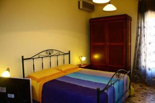 カステッランマーレ・デル・ゴルフォにあるAgliastri Apartmentsのベッドルーム1室(黄色と青の毛布付きのベッド1台付)