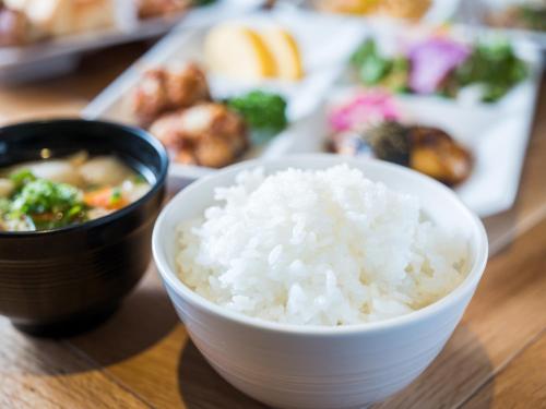a bowl of rice on a table with a plate of food at Super Hotel Takamatsu Tamachi in Takamatsu