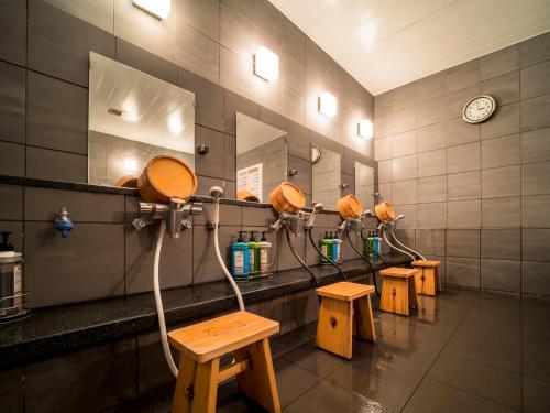 a row of chairs in a room with a row of urinals at Super Hotel Takamatsu Tamachi in Takamatsu