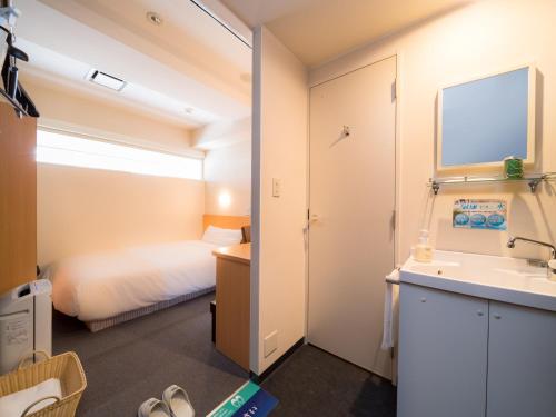 a small bathroom with a bed and a sink at Super Hotel Takamatsu Tamachi in Takamatsu