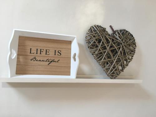 a shelf with a sign that reads life is beautiful and two hearts at The coach house in Grimston