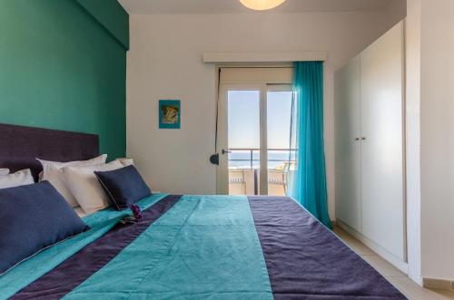 a bedroom with a bed with a view of the ocean at Pela Mare Hotel in Agia Pelagia