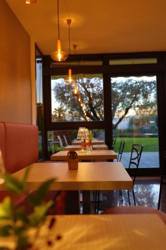 una sala da pranzo con tavoli e una grande finestra di Hotel Ulivi a Paratico