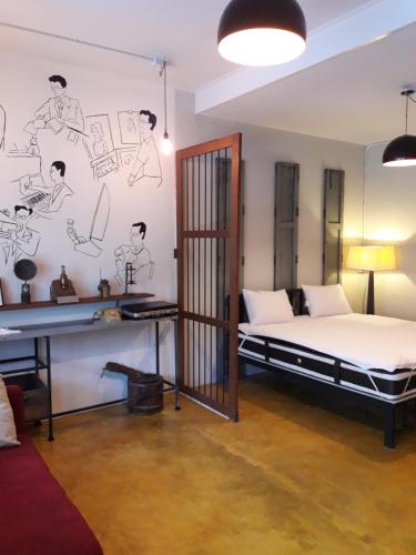 - une chambre avec un lit et un mur orné de dessins dans l'établissement Baan Hotelier Resort, à Trat