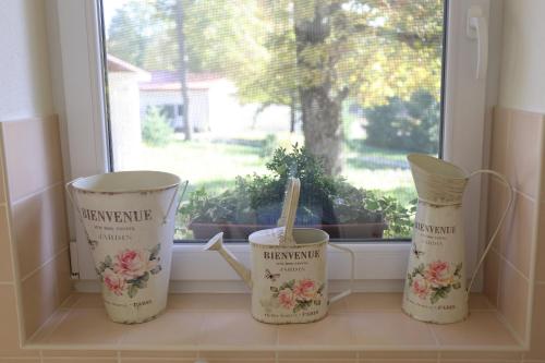 three buckets sitting on a window sill in front of a window at Apartmánový dom Harmónia in Modra