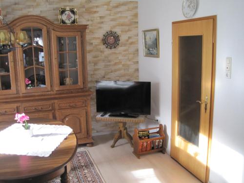 a living room with a television and a wooden cabinet at Ferienwohnung Weber in Schleiden