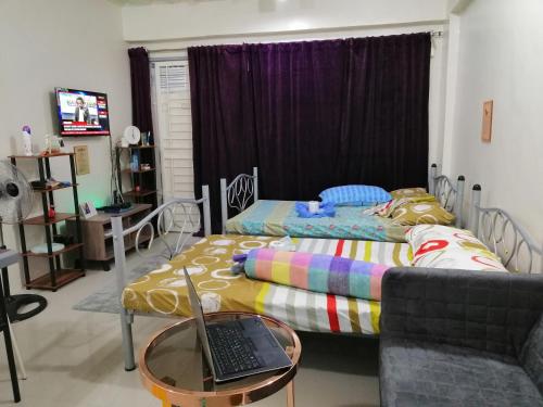 1 dormitorio con cama y mesa con ordenador portátil en Condo Near NAIA Airport T 1,2,3&4 v4, en Manila