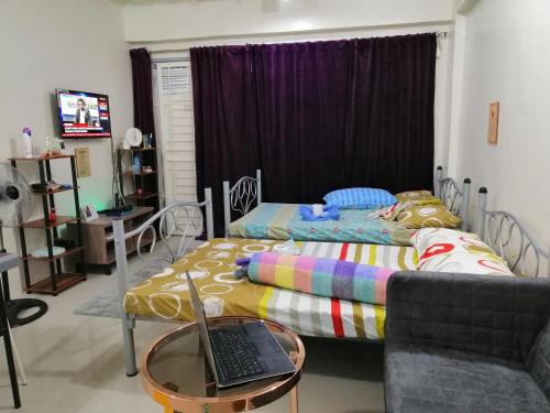 a bedroom with a bed and a laptop on a table at Condo Near NAIA Airport T 1,2,3&4 v4 in Manila