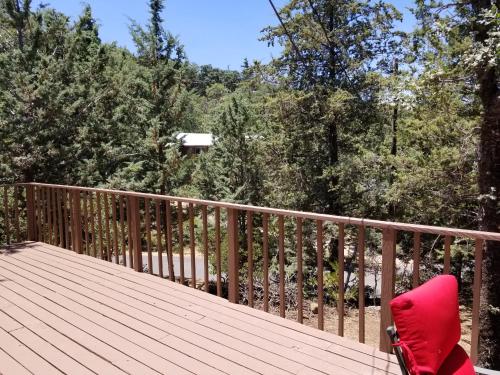 a red chair sitting on top of a wooden deck at Time Traveler Retreat in Julian