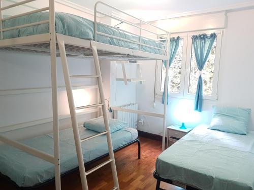 מיטה או מיטות קומותיים בחדר ב-Deba playa costa vasca