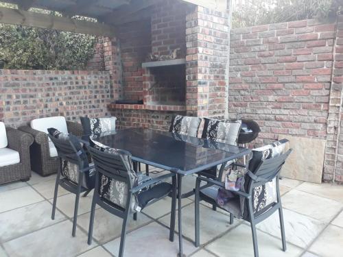 a black table and chairs on a patio at Lalapanzi in Fish hoek