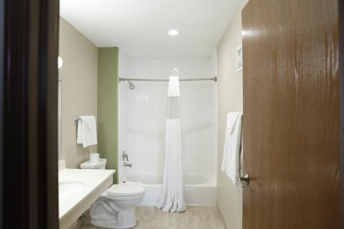 a white bathroom with a toilet and a sink at Baymont by Wyndham Rockford in Rockford