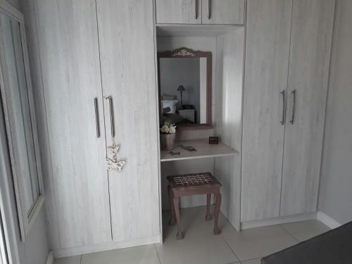 a white cabinet with a table in a room at Lalapanzi in Fish hoek
