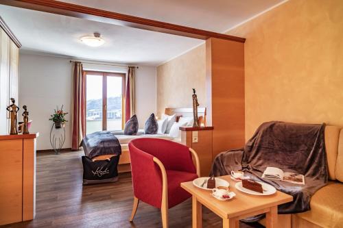 a hotel room with a bed and a table at Boutique Hotel Kircher in Sarntal