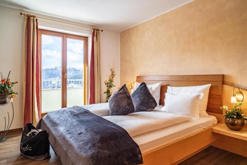 a bedroom with a large bed with a large window at Boutique Hotel Kircher in Sarntal
