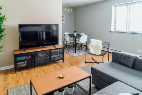 a living room with a couch and a tv at 1BR Stylish Apartment, Perfect for Getaway - Oakdale 201 in Chicago