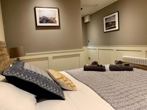a bedroom with a bed with two pillows on it at The Tower Arms Hotel in Iver