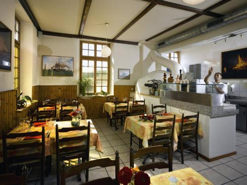 ein Restaurant mit Tischen und Stühlen in einem Zimmer in der Unterkunft Hotel de la Gare in Sugiez