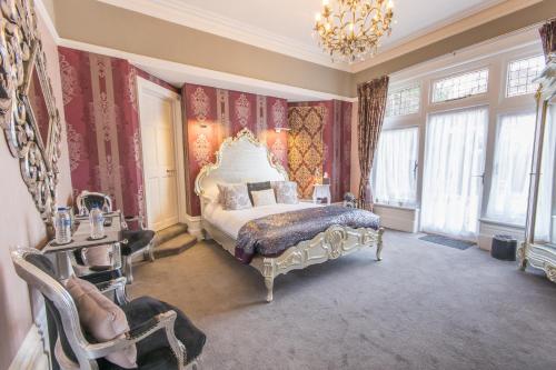 um quarto com uma cama king-size e um lustre em Grovefield Manor em Poole